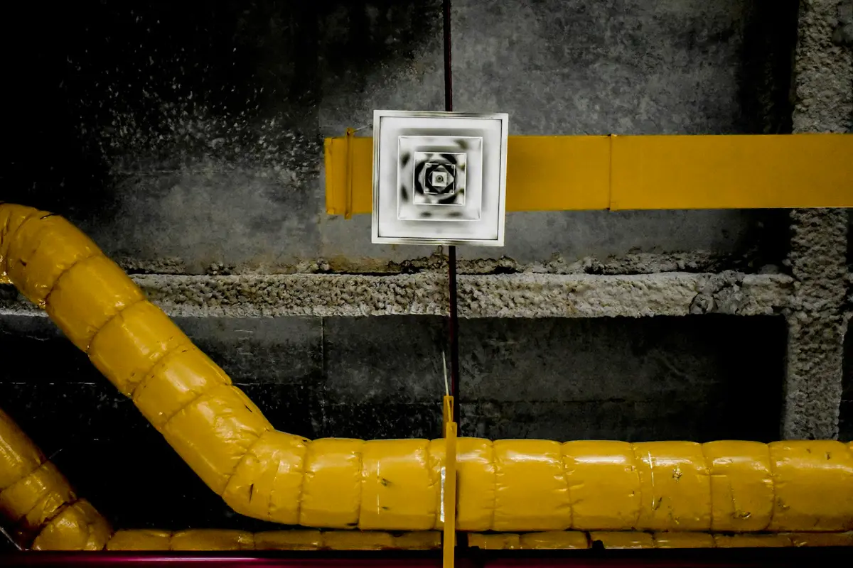 Insulated HVAC ductwork and a supply air diffuser in a building mechanical space