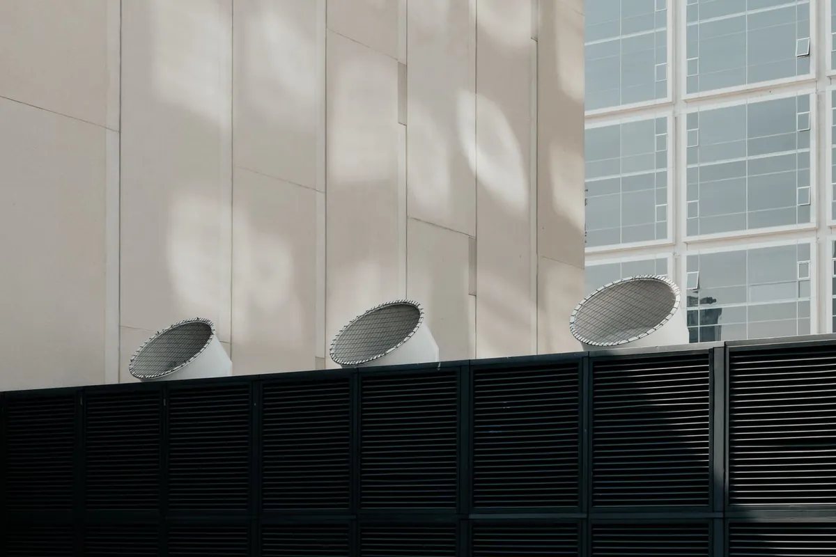 Rooftop air handling equipment with exhaust hoods and louvred intake panels on an industrial building